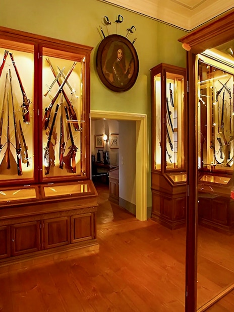 Cesky Krumlov Castle Museum interior with medieval armor and weaponry display.