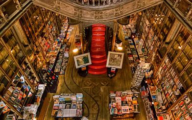 Top view of Lello Library's red staircase surrounded by bookshelves in Porto, Portugal.