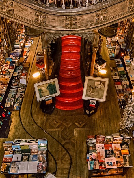 Top view of Lello Library's red staircase surrounded by bookshelves in Porto, Portugal.