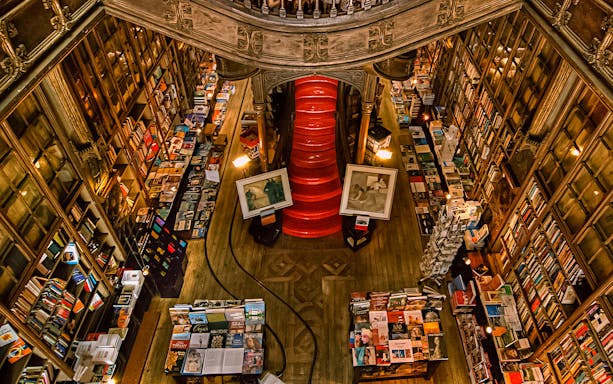 Top view of Lello Library's red staircase surrounded by bookshelves in Porto, Portugal.
