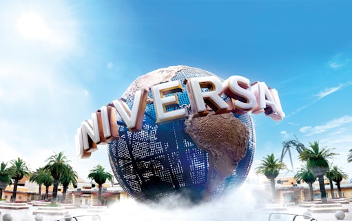 Universal Studios Japan globe with palm trees and roller coaster in background.