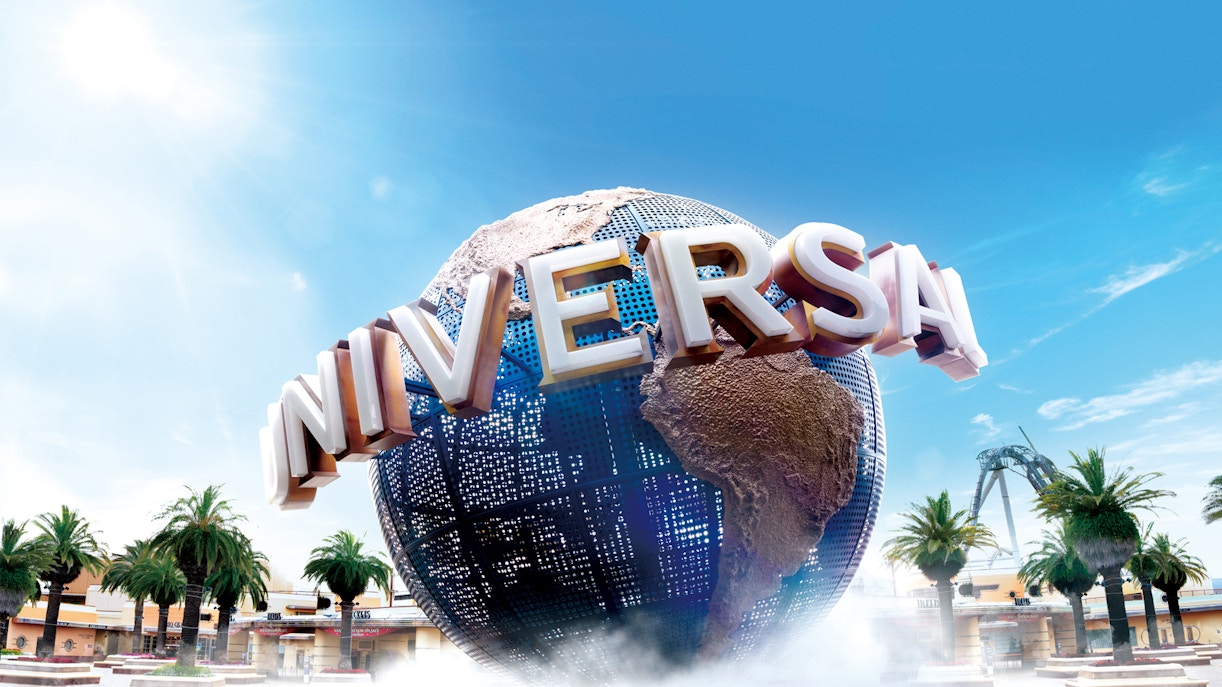 Universal Studios Japan globe with palm trees and roller coaster in background.