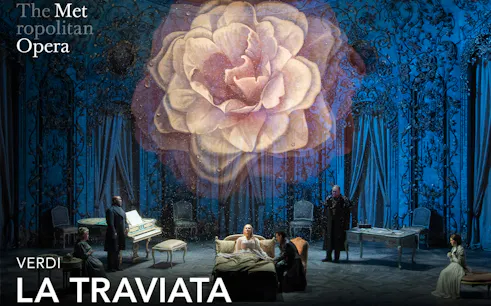 Opera scene from La Traviata at the Metropolitan Opera with a large flower backdrop.