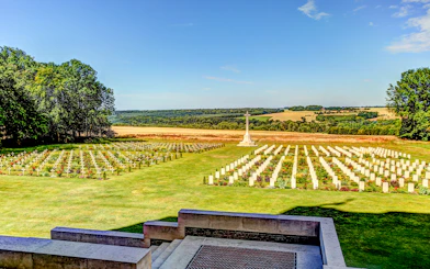 Somme battlefield cemetery with rows of white crosses and a memorial, France.