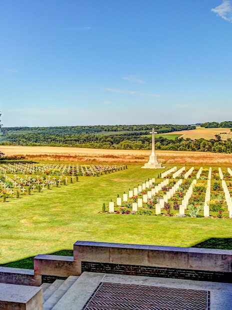 Somme battlefield cemetery with rows of white crosses and a memorial, France.