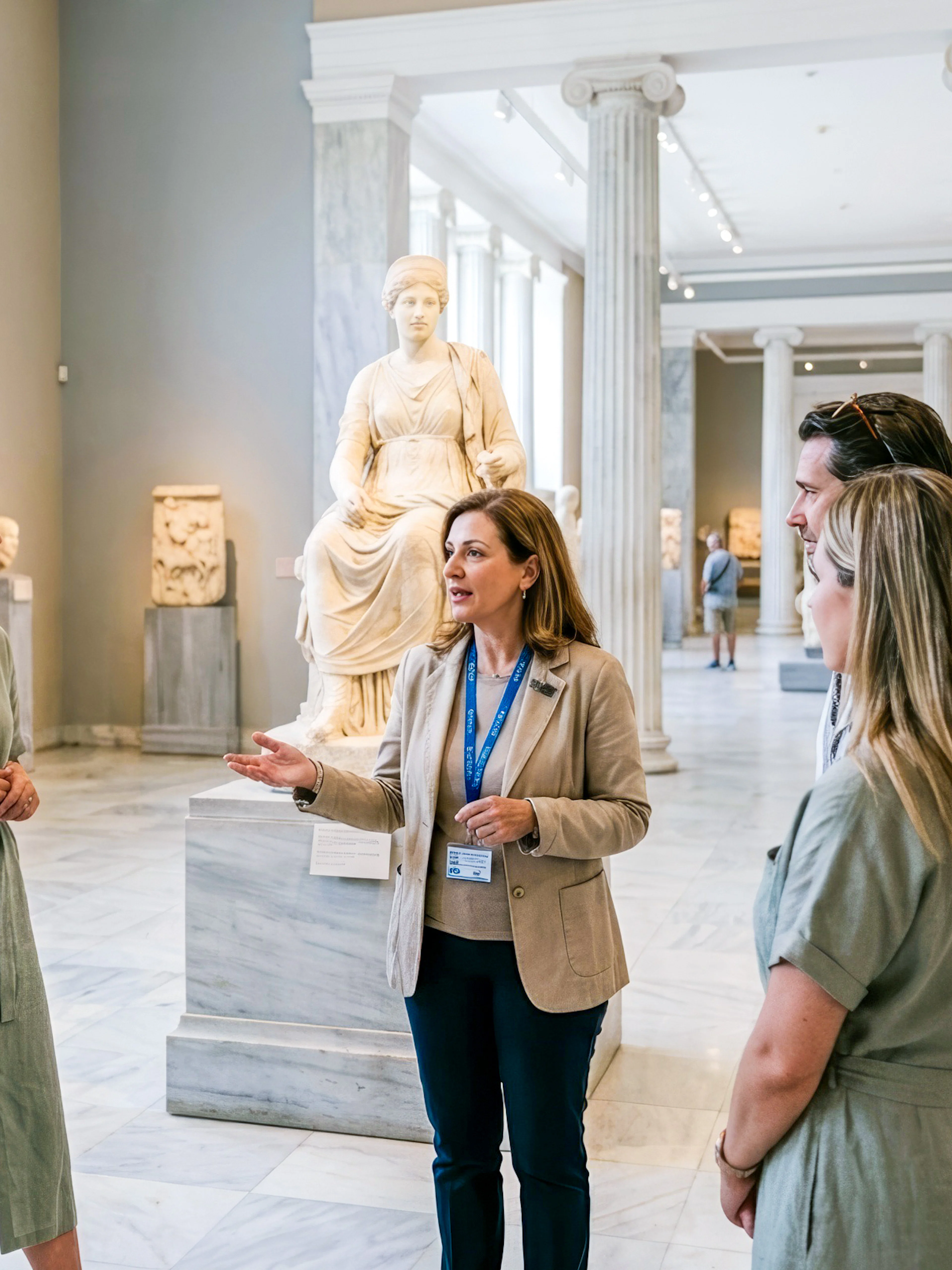 Tour group with guide at National Archaeological Museum, Athens, near ancient statue.