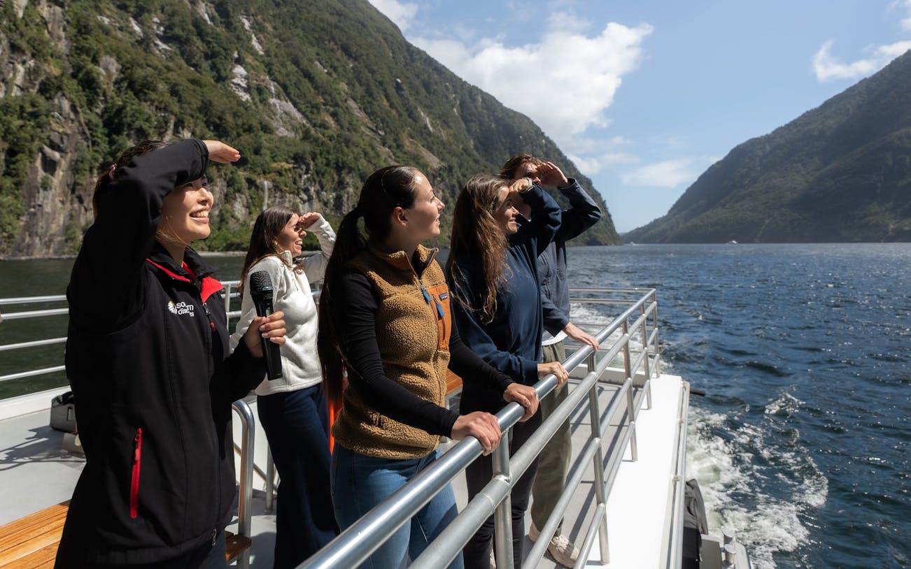 Tourists enjoying scenic views on a Milford Sound cruise from Te Anau.