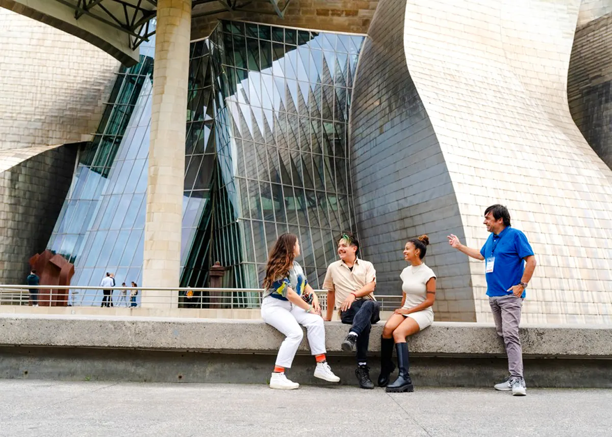 Group sitting outside Guggenheim Museum Bilbao during San Sebastian tour.