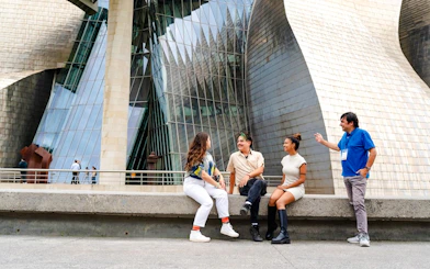 Group sitting outside Guggenheim Museum Bilbao during San Sebastian tour.