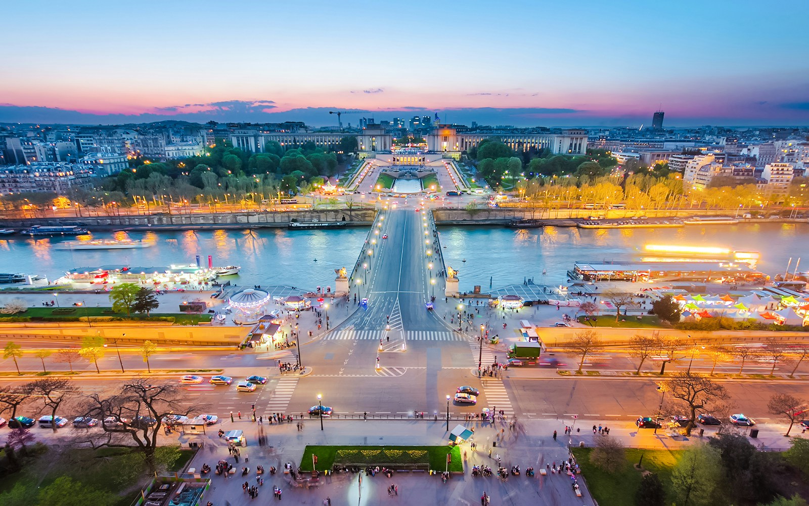 View of Paris from the Eiffel Tower during the light show, overlooking the Seine River and Trocadéro Gardens.