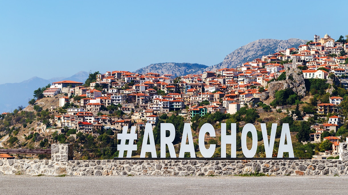 Arachova Village with hillside houses and large hashtag sign.