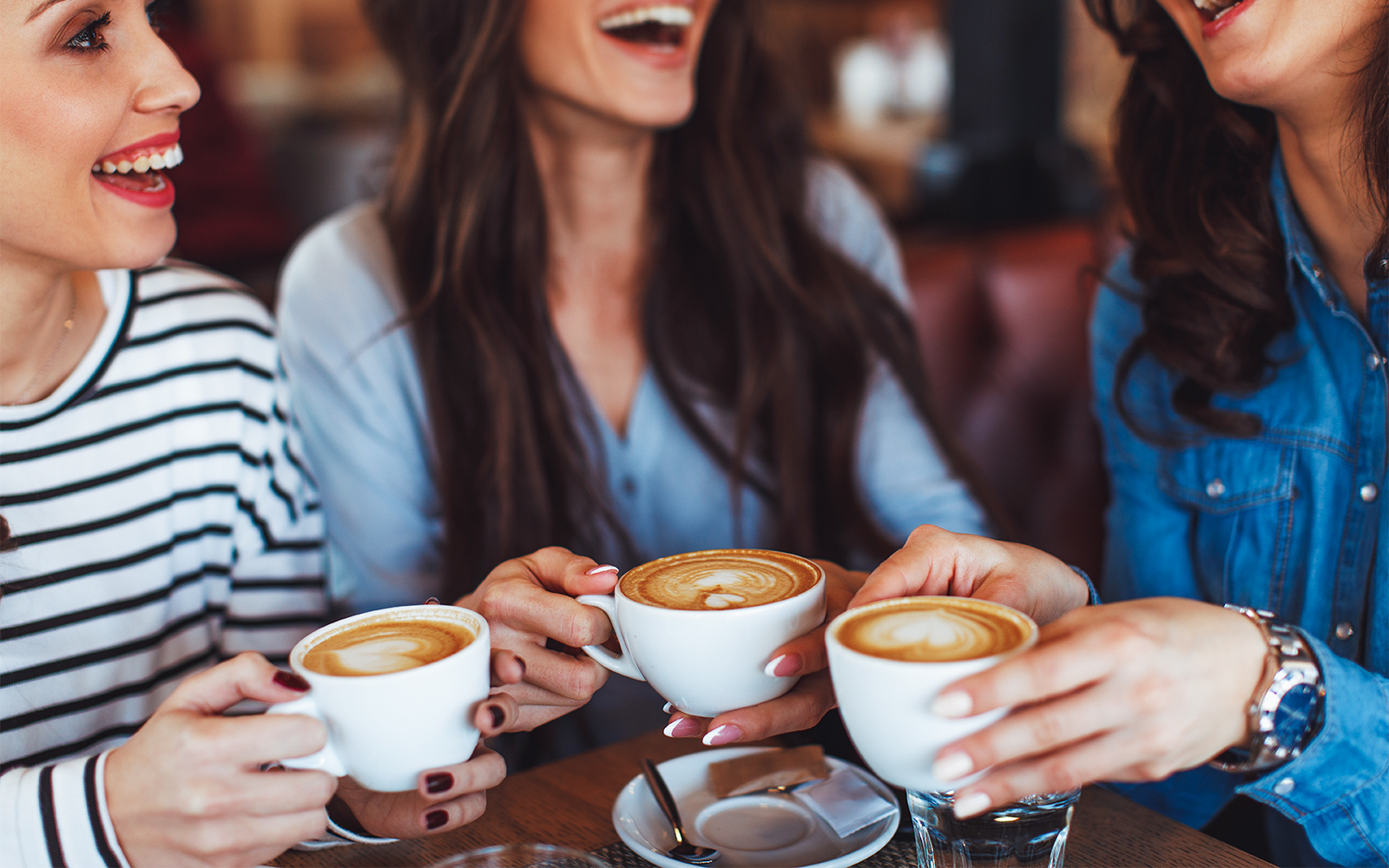 Friends enjoying coffee at NEMO Museum Amsterdam restaurant.