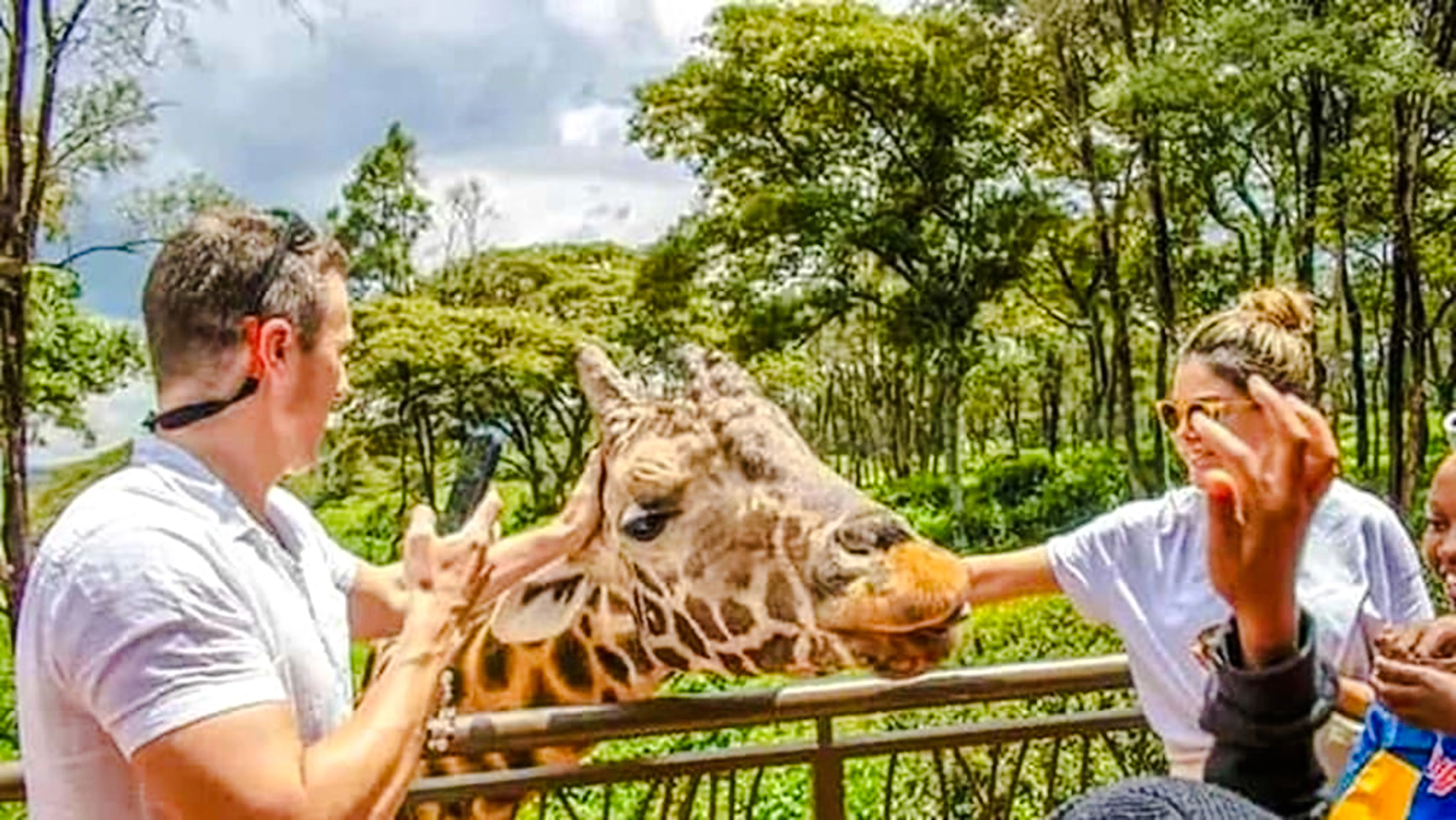 Visitors feeding a giraffe at Giraffe Centre, Nairobi.