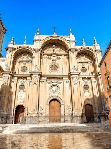 Granada Cathedral facade with ornate carvings and large wooden doors.