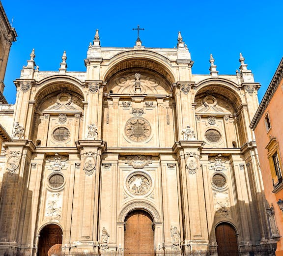 Granada Cathedral facade with ornate carvings and large wooden doors.