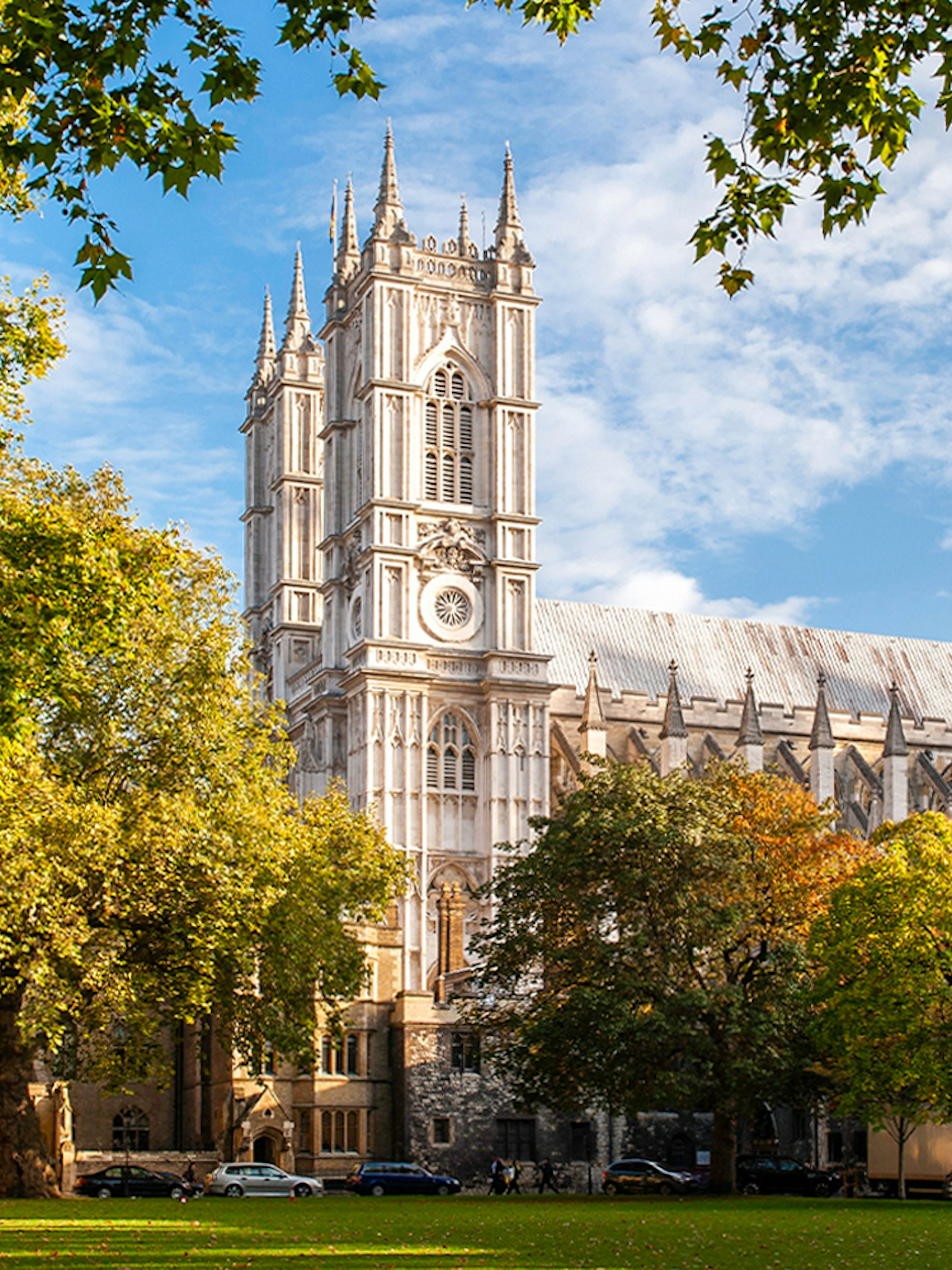 Westminster Abbey in London surrounded by trees on a sunny day.