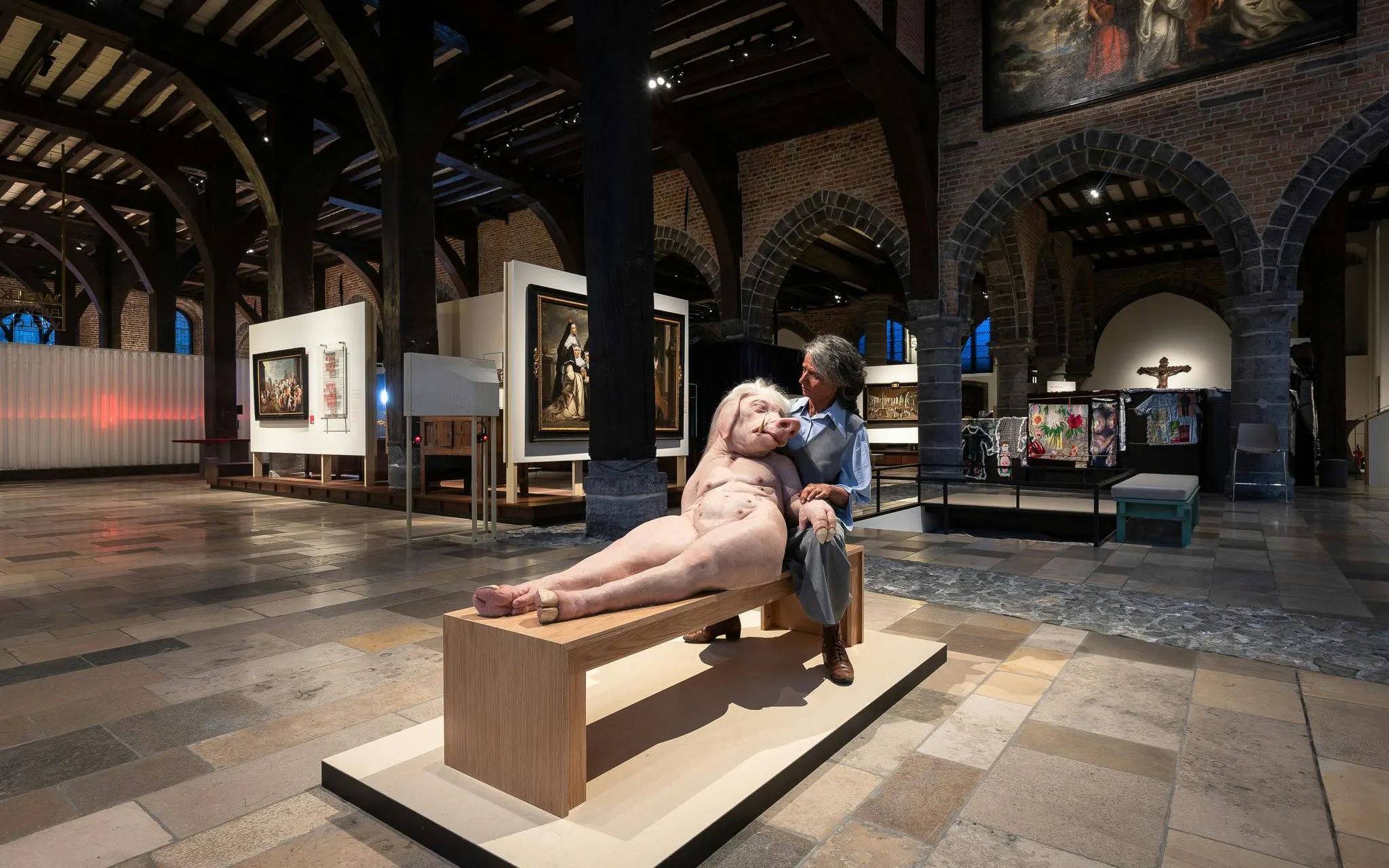 Exhibit inside Museum Sint-Janshospitaal featuring a unique sculpture and historical paintings.