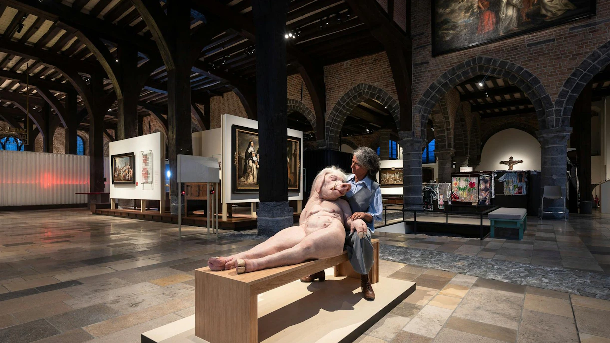 Exhibit inside Museum Sint-Janshospitaal featuring a unique sculpture and historical paintings.