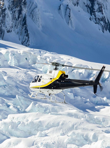 Helicopter approaching Franz Josef Glacier on scenic flight tour.