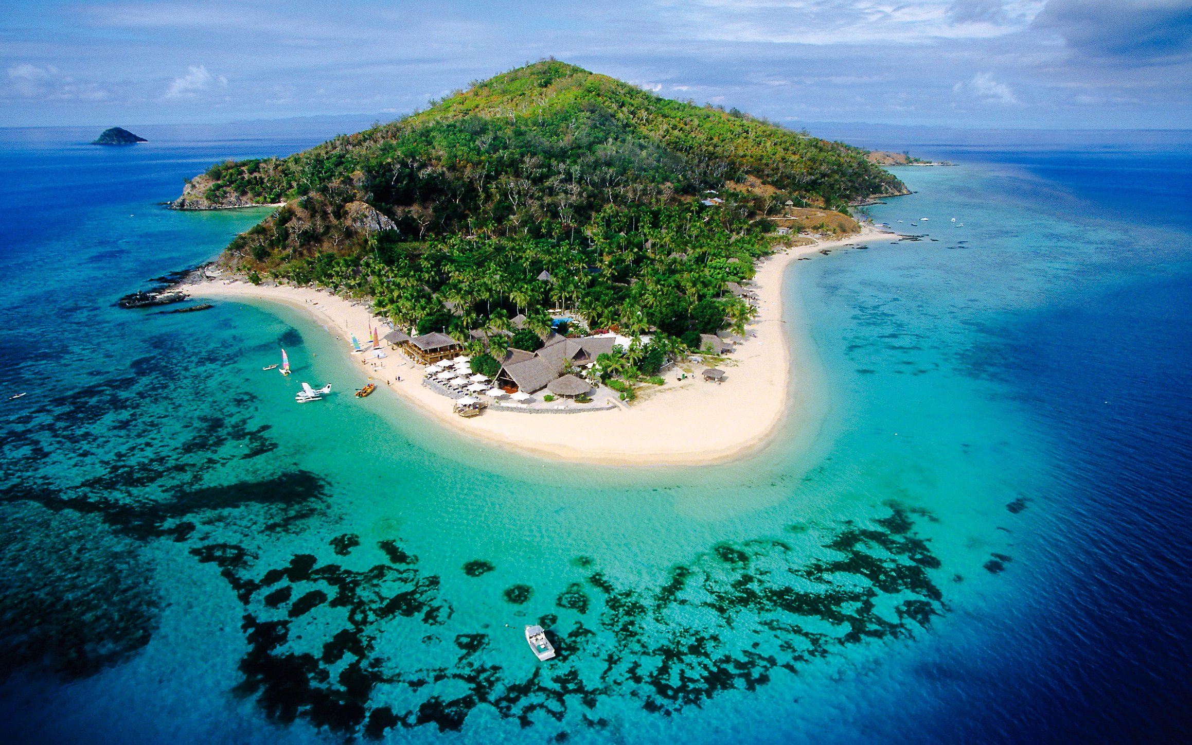 Aerial view of Castaway Island, Fiji with lush greenery and turquoise waters.