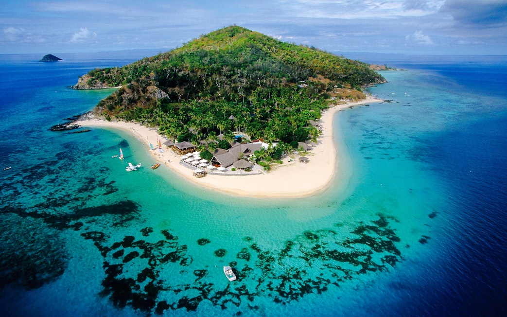 Aerial view of Castaway Island, Fiji with lush greenery and turquoise waters.