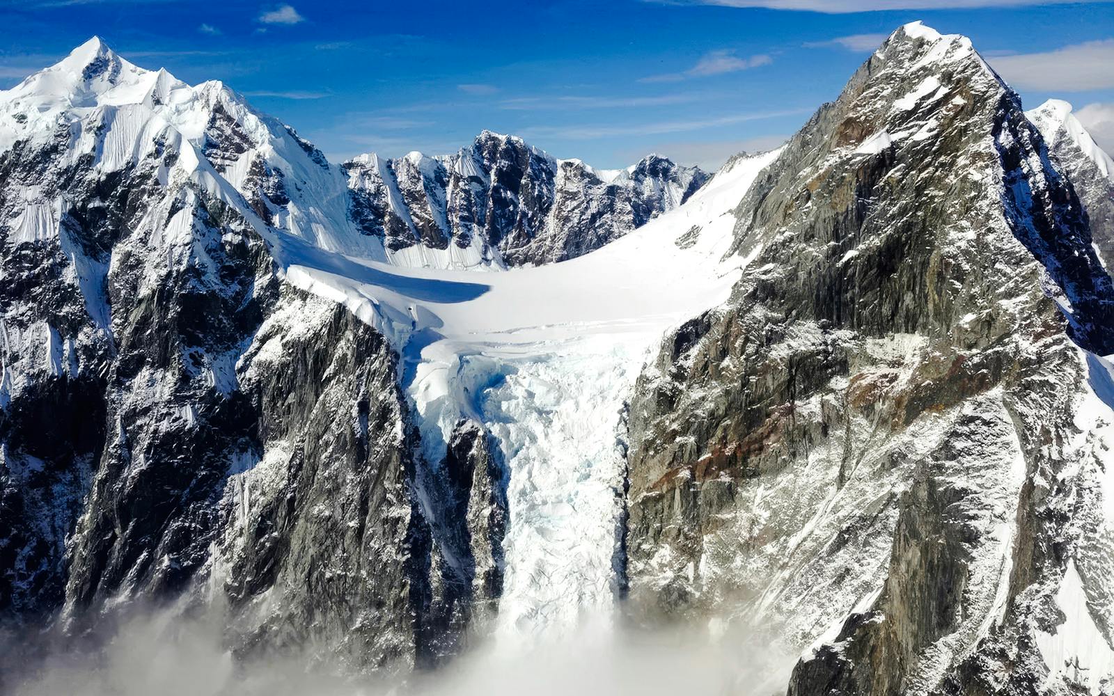 Helicopter view of snow-covered mountains and glacier in Juneau, Alaska.