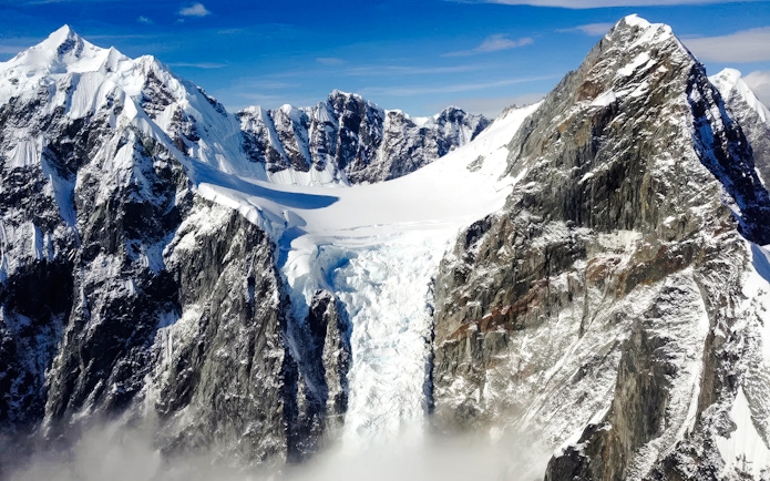Helicopter view of snow-covered mountains and glacier in Juneau, Alaska.