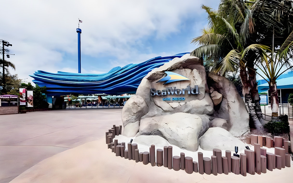 SeaWorld San Diego entrance with wave sculpture and palm trees.