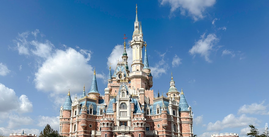 Enchanted Storybook Castle at Shanghai Disney Resort under a clear blue sky.