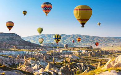 Hot air balloons over Cappadocia's unique rock formations and valleys.