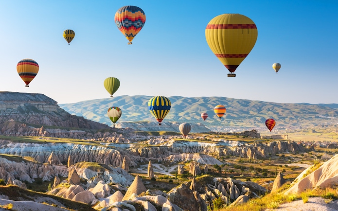 Hot air balloons over Cappadocia's unique rock formations and valleys.