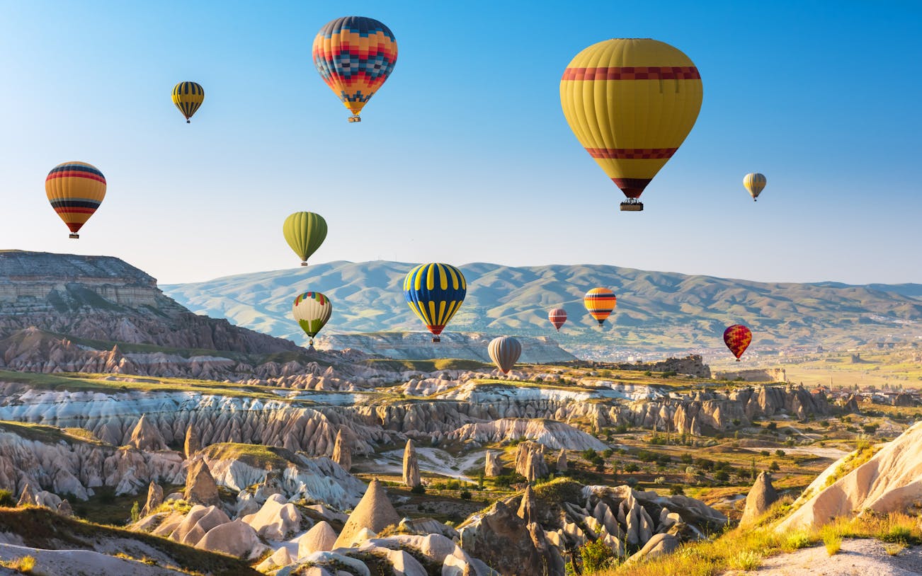 Hot air balloons over Cappadocia's unique rock formations and valleys.