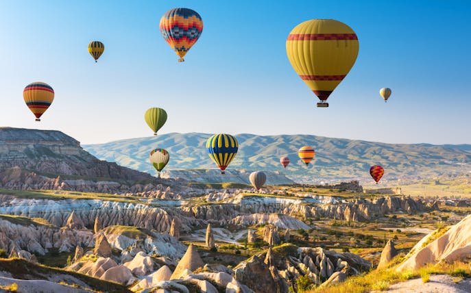 Hot air balloons over Cappadocia's unique rock formations and valleys.