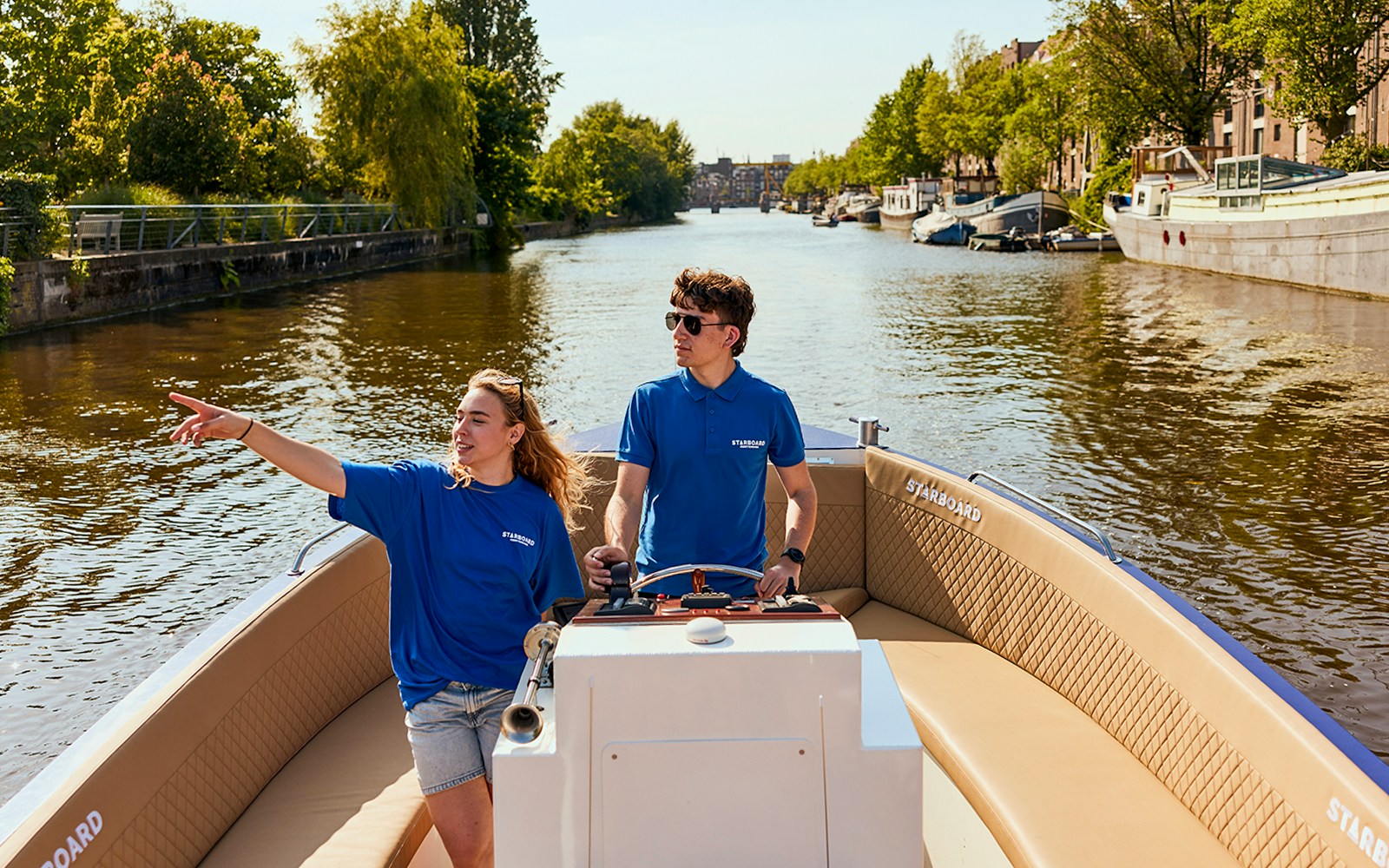 People enjoying a canal cruise in Amsterdam with unlimited drinks.