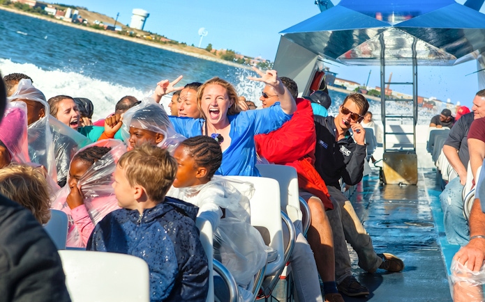 Passengers enjoying the CODZILLA thrill-boat ride in Boston, experiencing splashes and excitement.