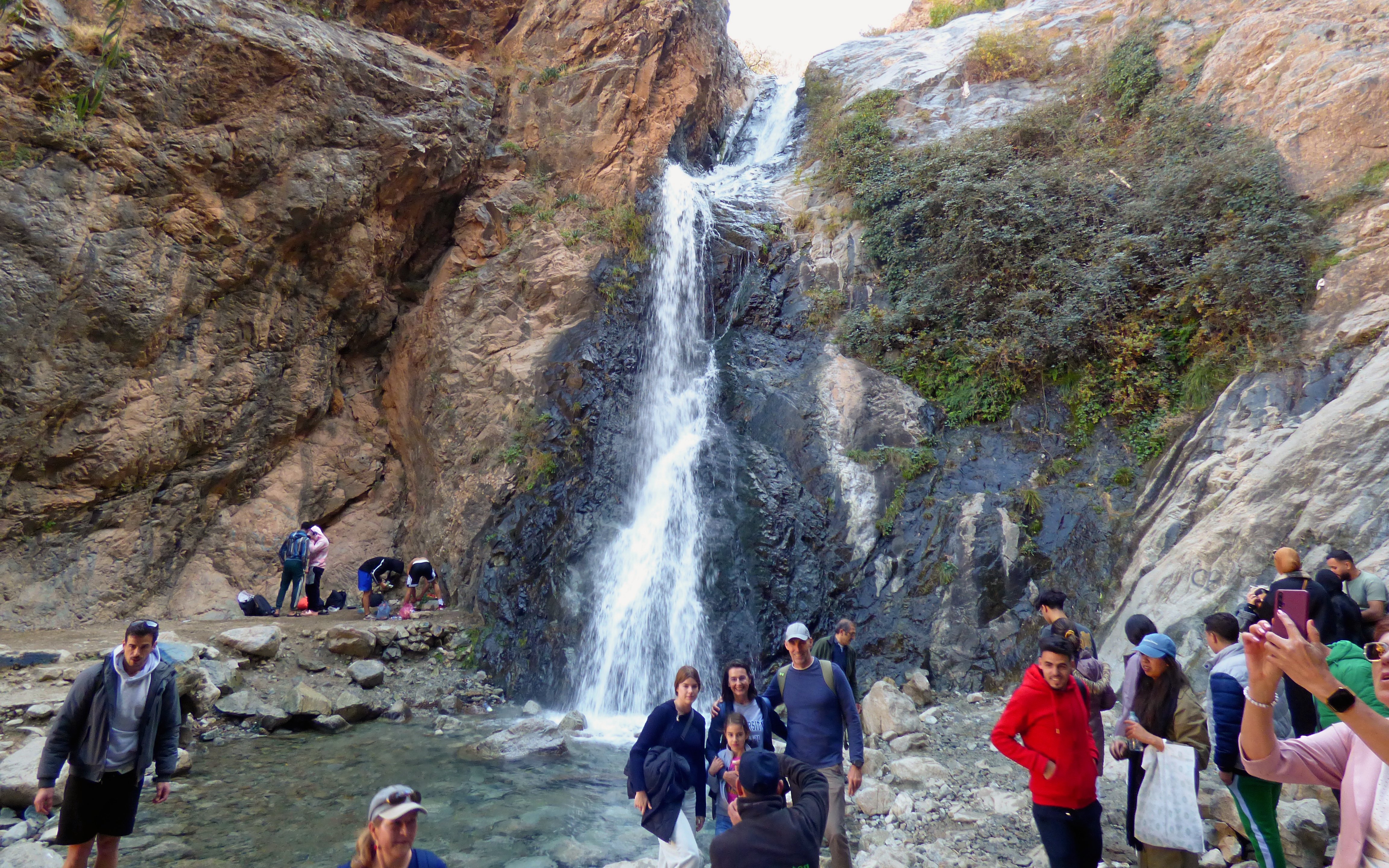 Visitors exploring a waterfall in Ourika Valley, Morocco.