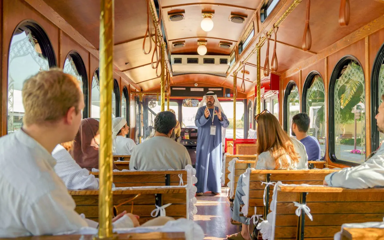 Tourists listening to an Emirati storyteller on a traditional trolley in Dubai.