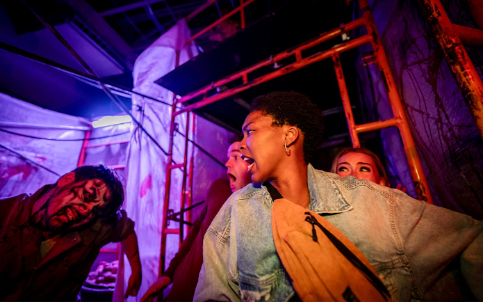 Visitors react in fear inside the SCarowinds Maze at Six Flags Snicker's Halloween Event.
