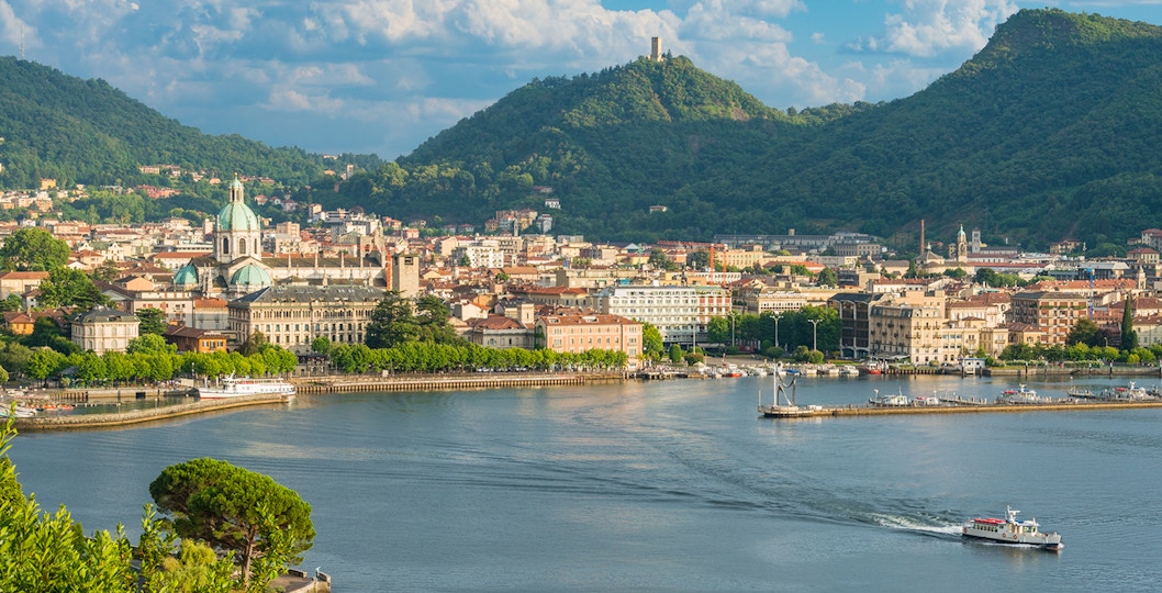 Panoramic view of Como city with Lake Como and surrounding mountains from Milan day trip.