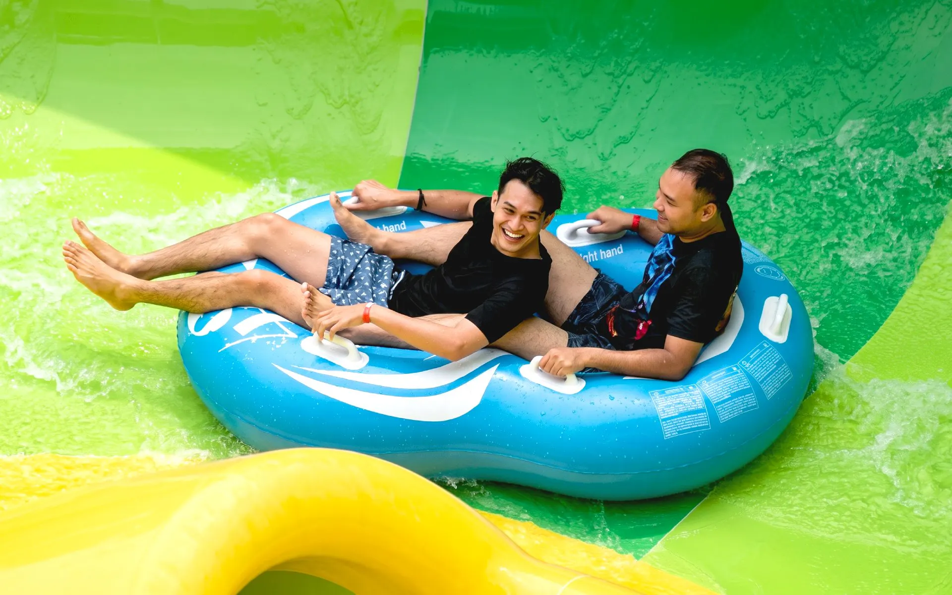 People riding a blue inflatable raft at SplashMania Waterpark.