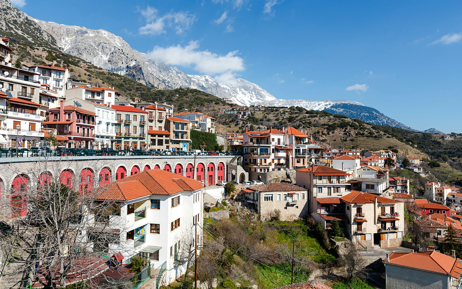 Arachova Village with traditional houses and snow-capped mountains in the background.