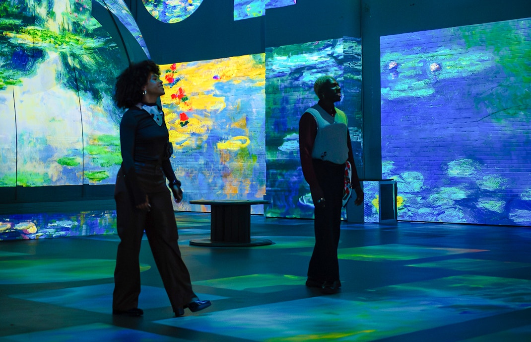Visitors exploring Monet exhibition at Fabrique des Lumières with immersive digital art displays.