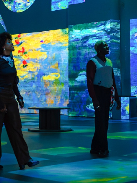 Visitors exploring Monet exhibition at Fabrique des Lumières with immersive digital art displays.