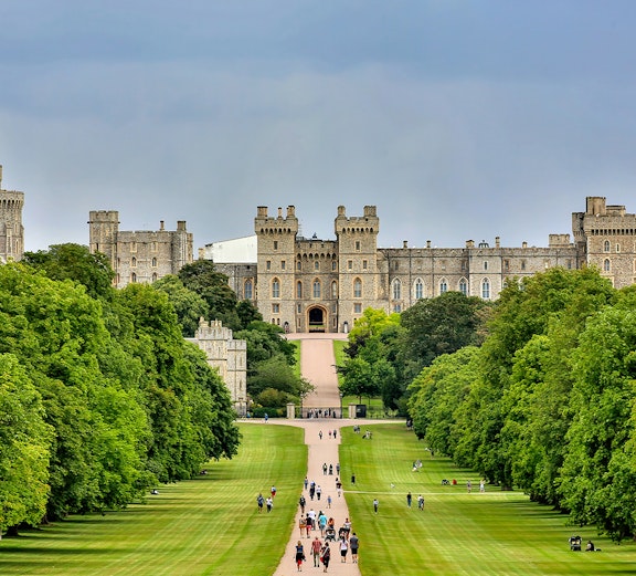 Windsor Castle with tourists walking along the Long Walk, London to Windsor Castle tours.