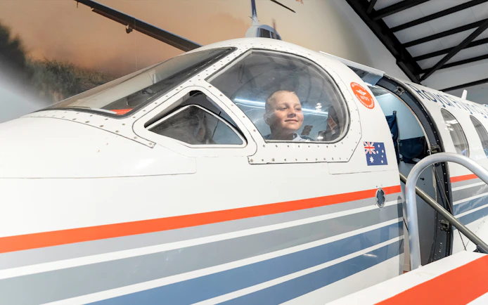 Child inside Royal Flying Doctor Service plane exhibit in Darwin, Australia.
