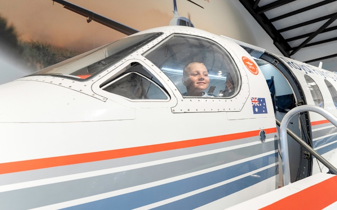 Child inside Royal Flying Doctor Service plane exhibit in Darwin, Australia.