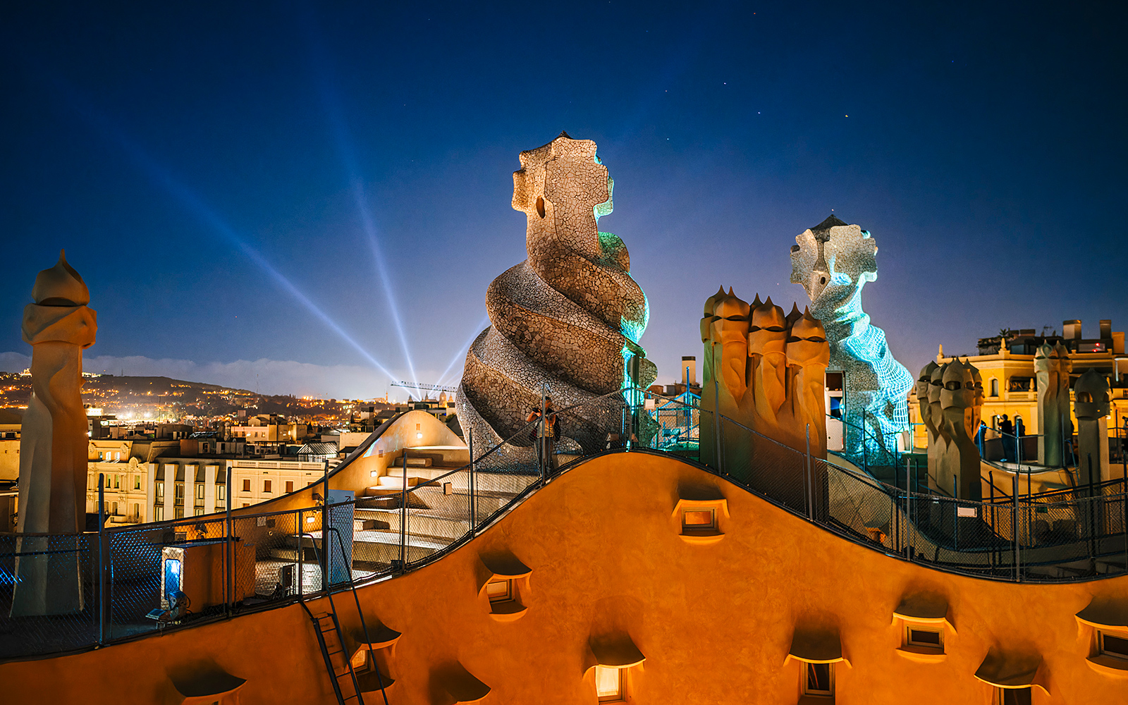 Casa Mila rooftop chimneys illuminated during the La Pedrera Night Experience in Barcelona.