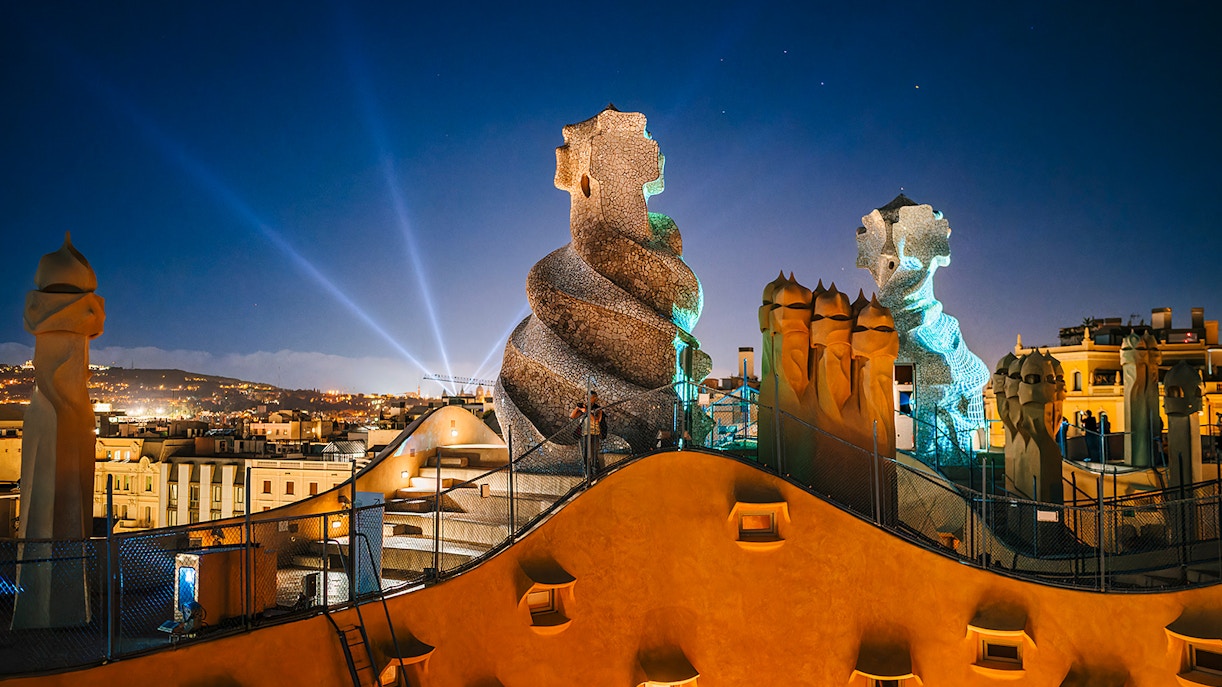 Casa Mila rooftop chimneys illuminated during the La Pedrera Night Experience in Barcelona.