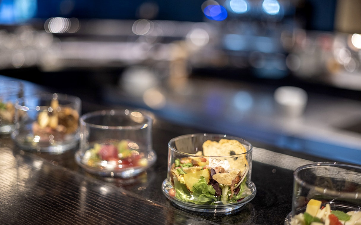 Czech tapas cuisine tasting with assorted food and cocktails on a bar counter.