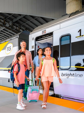 Family boarding Brightline train from Miami to Orlando.